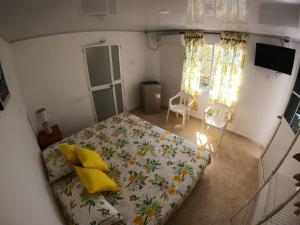 um quarto com uma cama com almofadas amarelas em Native Lodge Brisas del Sur em Providencia