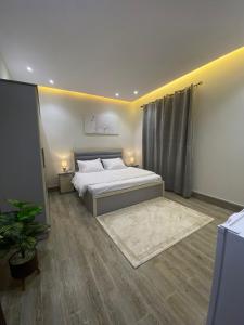 - une chambre avec un lit et une plante en pot dans l'établissement شقة فاخرة غرفة نوم وصالة, à Riyad