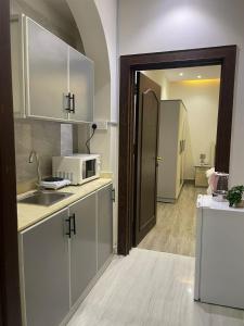 a kitchen with a sink and a microwave at شقة فاخرة غرفة نوم وصالة in Riyadh