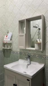 La salle de bains est pourvue d'un lavabo et d'un miroir. dans l'établissement شقة فاخرة غرفة نوم وصالة, à Riyad