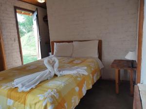 een slaapkamer met een bed met handdoeken erop bij Solar dos Pinhais in Santo Antônio do Pinhal