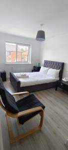 a bedroom with a large bed and a chair at H8 Room 3 Serene Home with 15 min walk to City Centre, Free car parking,Late Night Check In Anytime, 2 min walk to Bus Stop in Manchester