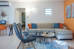 sala de estar con sofá, sillas y mesa en Diver's Paradise Bonaire en Kralendijk
