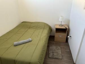 a small bedroom with a bed and a night stand at Morada in Tacna