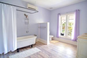 La salle de bains est pourvue d'une baignoire blanche et d'une fenêtre. dans l'établissement Blue Sky Manor, à Interlachen