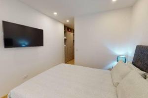 1 dormitorio con 1 cama y TV de pantalla plana en Apartamento con Terraza cerca a Unicentro, en Bogotá