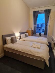 um quarto de hotel com duas camas e uma janela em Pilrig St Rooms em Edimburgo
