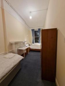 a hotel room with two beds and a bathroom at Pilrig St Rooms in Edinburgh