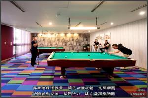蘆竹區的住宿－富立登國際大飯店，一群人在带台球桌的房间里打台球
