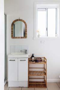 a white bathroom with a sink and a mirror at Saltwood in Bridport
