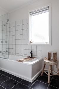 a white bathroom with a tub and a window at Saltwood in Bridport