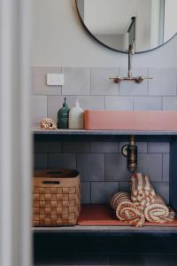 een plank met handdoeken en een wastafel in de badkamer bij Stony Rise Lodge in Robe