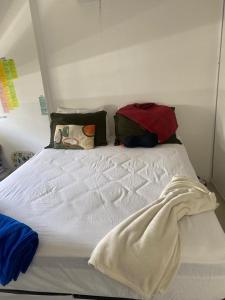 a white bed with several pillows on top of it at Apartamento Top in Fortaleza