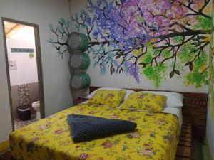 a bedroom with a bed with a painting on the wall at Hostal Macondo Inn in Carmen de Viboral