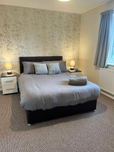 a bedroom with a large bed with two lamps at Pinecone Cottage in Frodingham