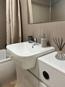 a white bathroom with a sink and a mirror at Pinecone Cottage in Frodingham