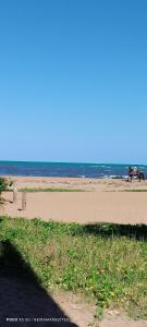 una playa con gente montando caballos en la arena en pousada beira mar suites São Bento en Maragogi