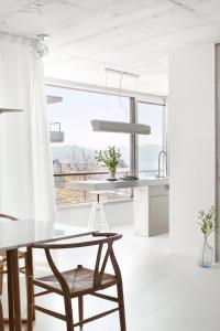 a white kitchen with a table and a chair at Beautiful design Belem Ap 115m2 in Lisbon