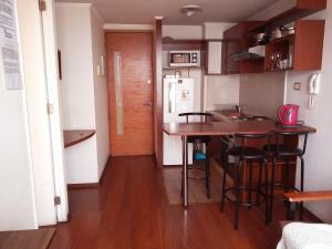 a small kitchen with a table and some stools at Metroapart 1 in Santiago