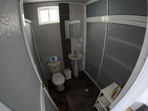 a small bathroom with a toilet and a sink at Native Lodge Brisas del Sur in Providencia