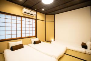 two twin beds in a room with a window at 東雲庵/shinonomean in Kyoto
