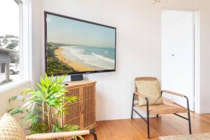 ein Wohnzimmer mit einem TV an der Wand in der Unterkunft Beachside Gem in Ocean Grove in Ocean Grove