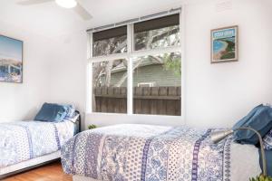 um quarto com 2 camas e uma janela em Beachside Gem in Ocean Grove em Ocean Grove