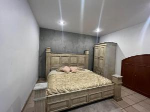 um quarto com uma cama de madeira com duas almofadas em Casa Serena - Casa de Huéspedes em Guadalajara