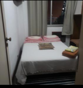 uma pequena cama num quarto com uma janela em Aconchego da te no Rio de Janeiro