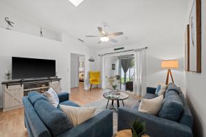 a living room with blue couches and a flat screen tv at Sunshine Home and Romantic Vacation in Sarasota