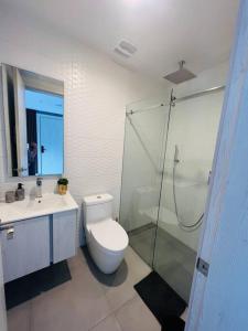 a bathroom with a toilet and a glass shower at La Carolina - Studio de lujo in Quito