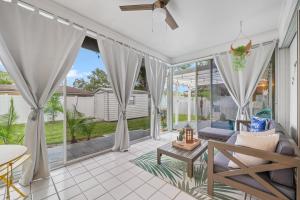een woonkamer met witte gordijnen en een bank bij Sunshine Home and Romantic Vacation in Sarasota