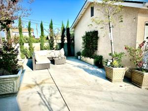 a patio with couches and potted plants in front of a house at Central Location Family Size Home in Temple City
