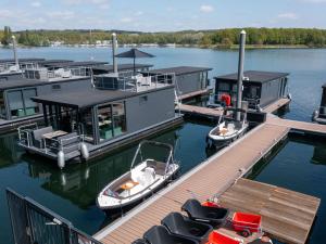 two boats are docked at a dock on a lake at Houseboat Mookerplas with a view in Middelaar
