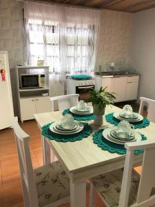 eine Küche mit einem weißen Tisch mit Stühlen und einem Tisch in der Unterkunft Residência Vô José - Casa 02 in Pomerode