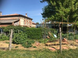 a garden with a fence in front of a building at Escapade dans la campagne toulousaine in Beaumont-sur-Lèze