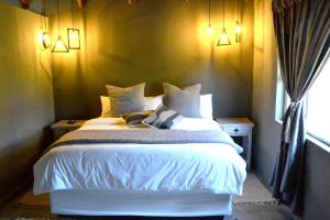1 dormitorio con cama blanca y ventana en Bradbury Game Lodge and Function Venue, en Polokwane