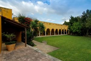 a courtyard of a building with a green lawn at Hacienda Misne in Mérida