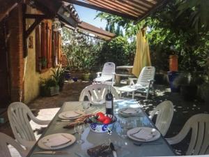 a table with white chairs and a bottle of wine at Escapade dans la campagne toulousaine in Beaumont-sur-Lèze