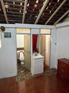 ein Bad mit einem Waschbecken und einem WC in einem Zimmer in der Unterkunft Hostal Voyager La Villa de Los Santos, Panama in Los Santos