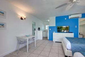 a bedroom with a bed and a table and a kitchen at Castle by the Sea Motel in Fort Lauderdale