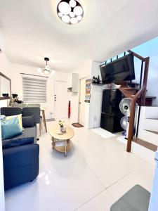 a living room with a blue couch and a tv at Two-Bedroom Townhouse Camella Bacolod South in Bacolod