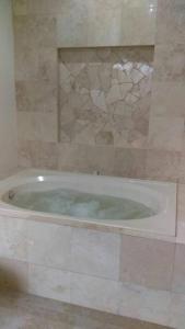 uma casa de banho com uma banheira com bolhas em Villa Colibri Casa Vacacional alberca asador jardín 15 huéspedes em Temixco