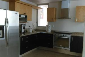 una cucina con frigorifero e armadietti in acciaio inossidabile di Villa Colibri Casa Vacacional alberca asador jardín 15 huéspedes a Temixco