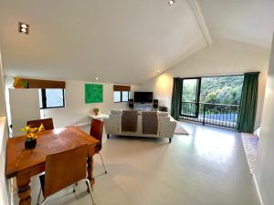 The Studio, Whangarei Heads في وانغاري: غرفة معيشة مع طاولة وأريكة