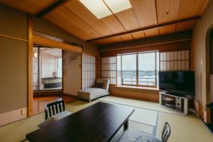 a living room with a table and a television at Tokigasane in Kaga