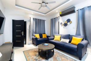 Villa Camilla في أوتشو ريوس: غرفة معيشة مع أريكة زرقاء ووسائد صفراء