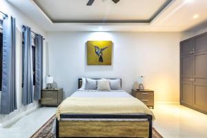 Villa Camilla في أوتشو ريوس: غرفة نوم بسرير ودهان على الحائط
