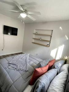 a bedroom with a couch and a ceiling fan at Large 3 Bedroom Home 12 Minutes to Beach in Clearwater