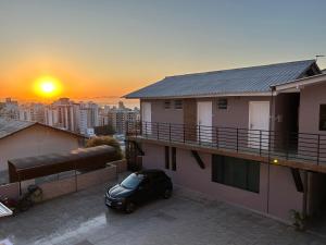 a car parked on the balcony of a house with the sunset at Casas de Floripa in Florianópolis